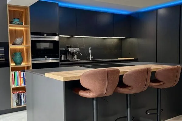handleless kitchen with dark graphite cabinetry, oak island and integrated appliances
